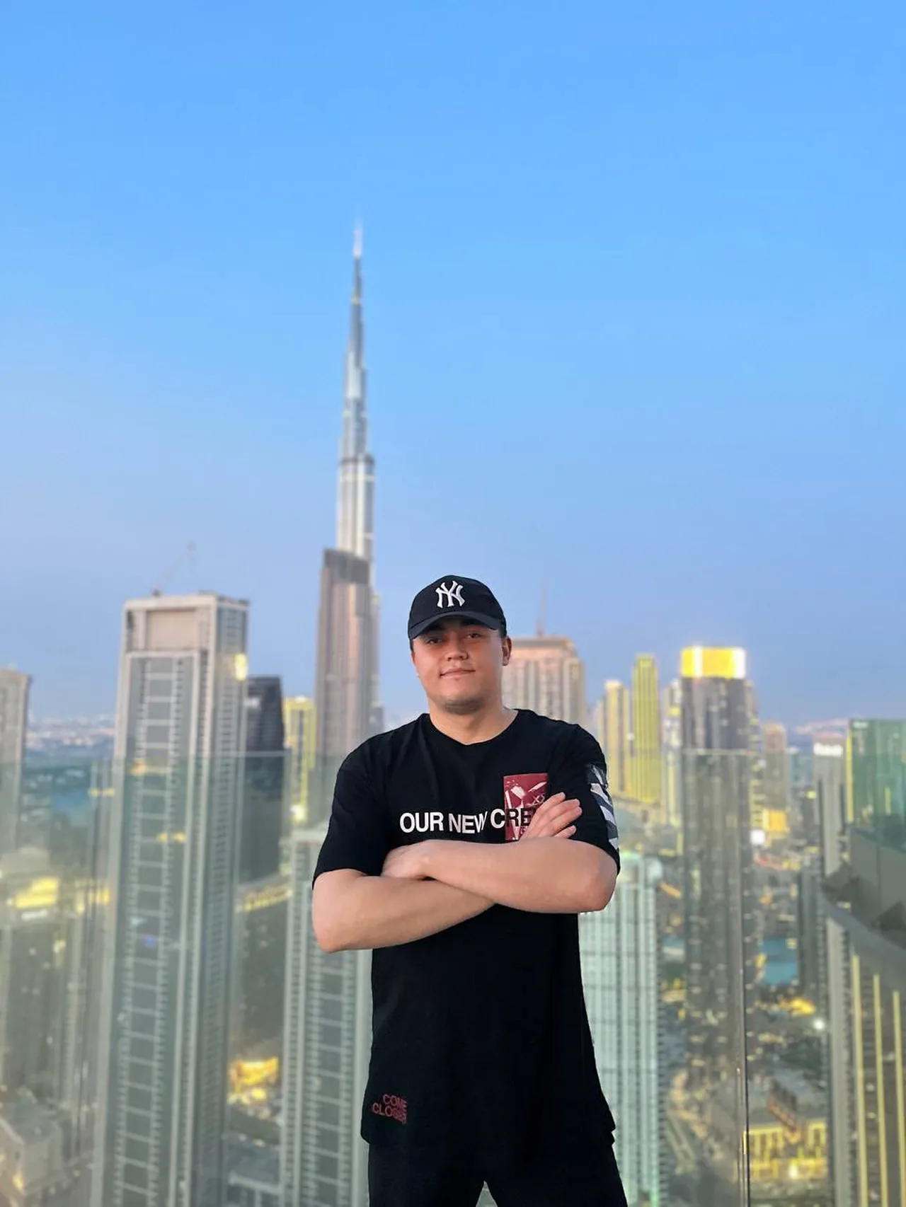 Said in a cap on a balcony above Downtown Dubai, arms folded, the Burj Khalifa behind him